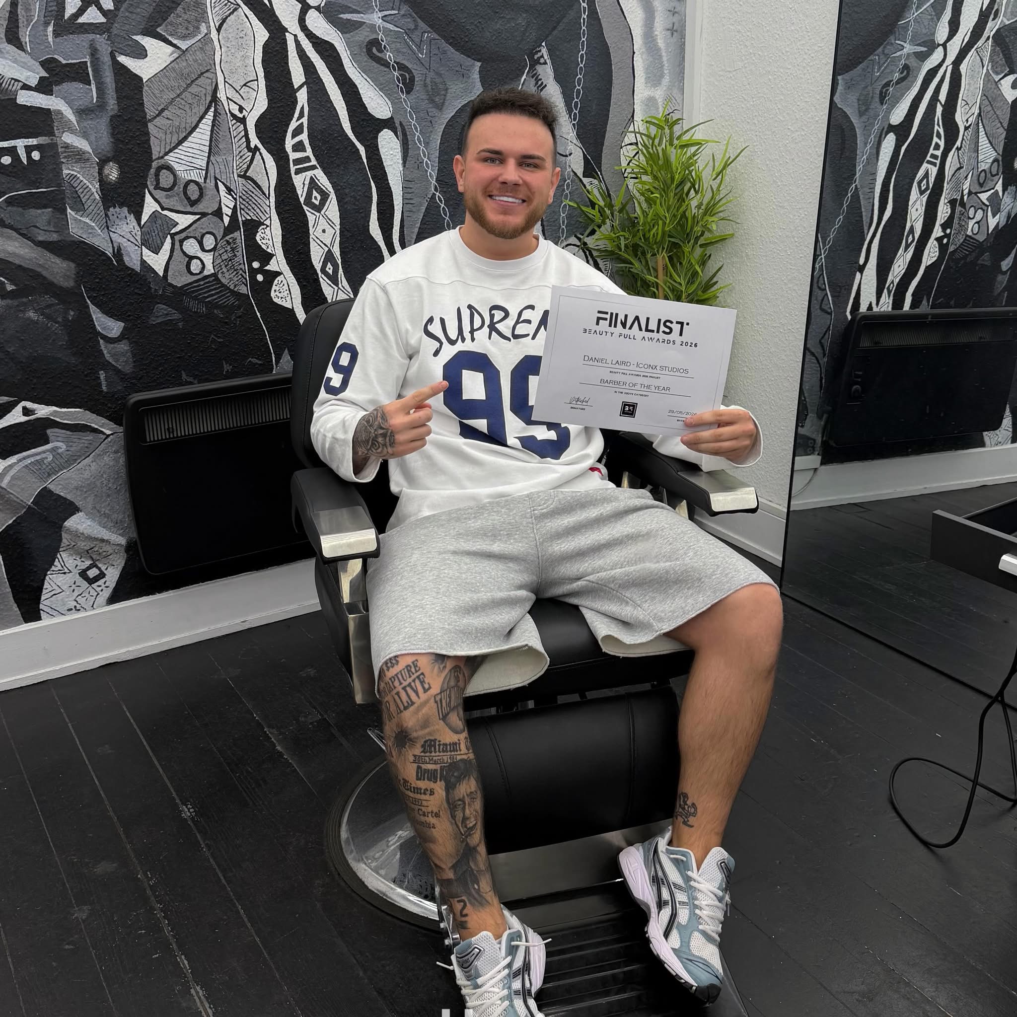 Dan in the ICONX studio holding his barber award finalist certificate